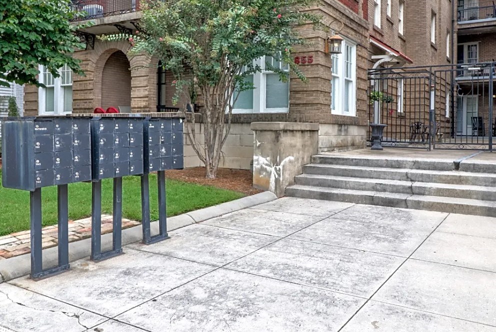 a row of mailboxes on a sidewalk in front of a building