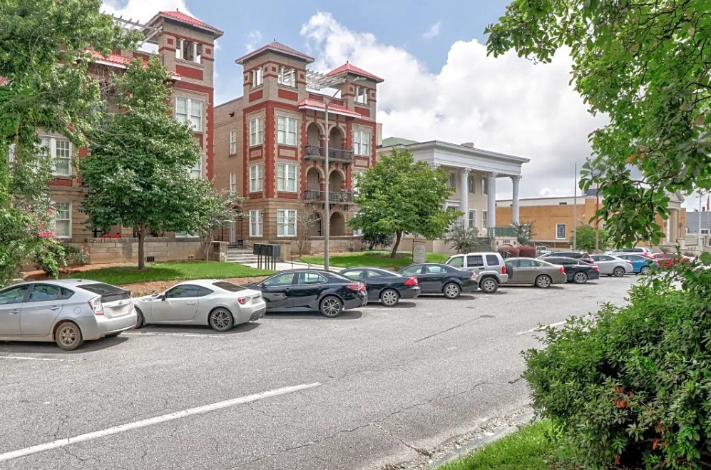 a parking lot full of cars in front of a building