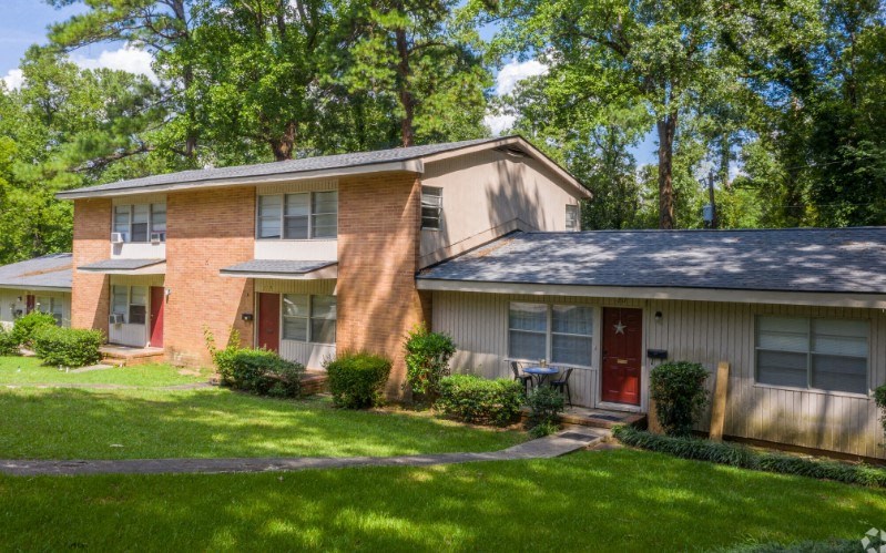 a house with a red door and a green lawn