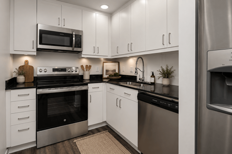 A modern kitchen with white cabinets and stainless steel appliances.