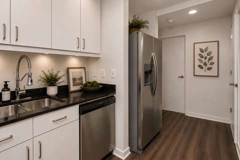 A modern kitchen with a stainless steel refrigerator and white cabinets.