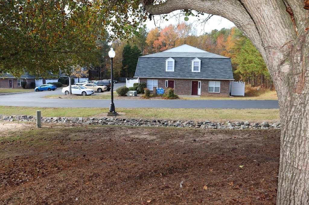 a house on the corner of a street with a tree