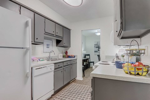 A kitchen with a white refrigerator and a white washing machine.