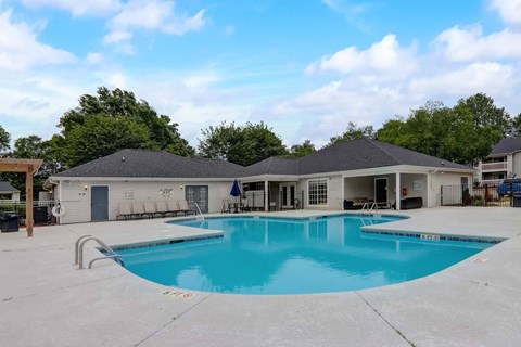 A large outdoor swimming pool with a building in the background.