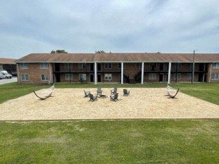 a patio with chairs and tables in front of a building