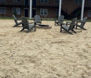 a group of chairs sitting on top of a sandy beach