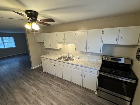 A kitchen with white cabinets and a black stove top oven.