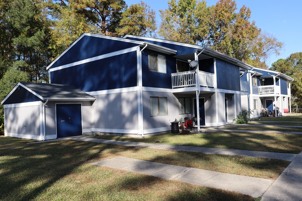 a blue and white house with trees in the background