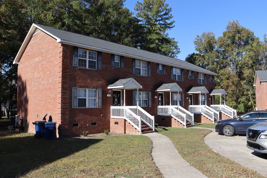 a red brick house with a porch and white stairs