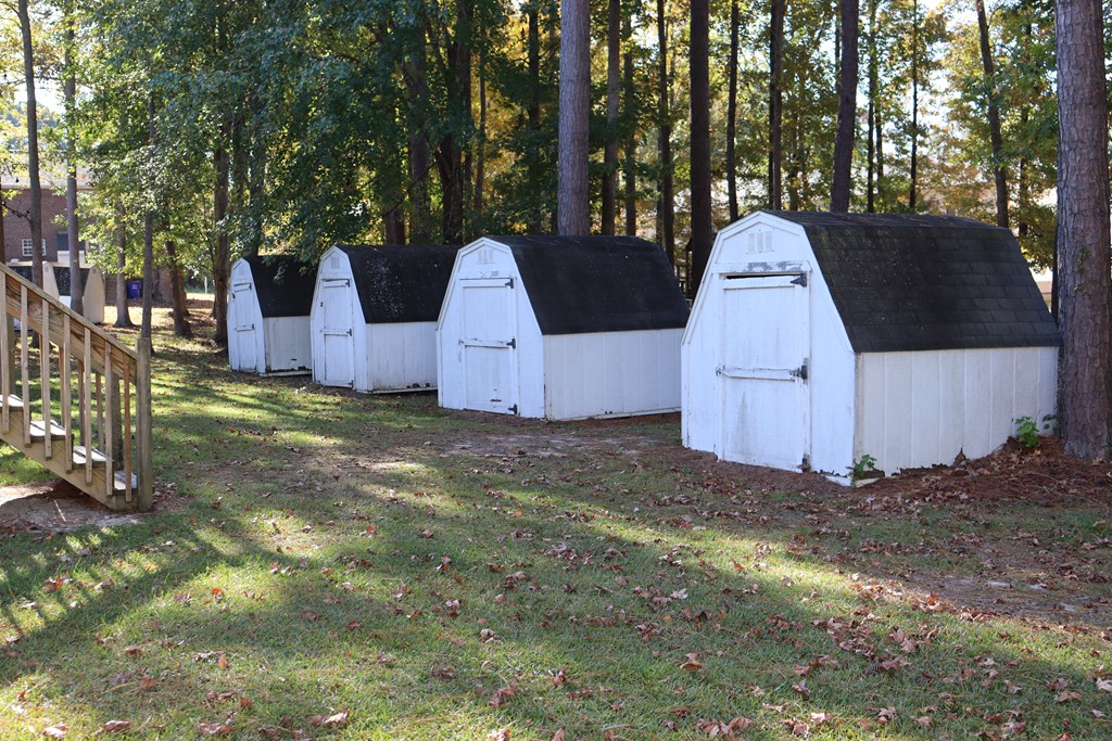 a row of white tents in the woods