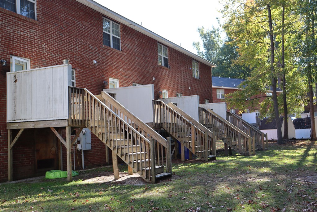 a row of wooden stairs in front of a brick building