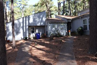the front of a house with a driveway and trees