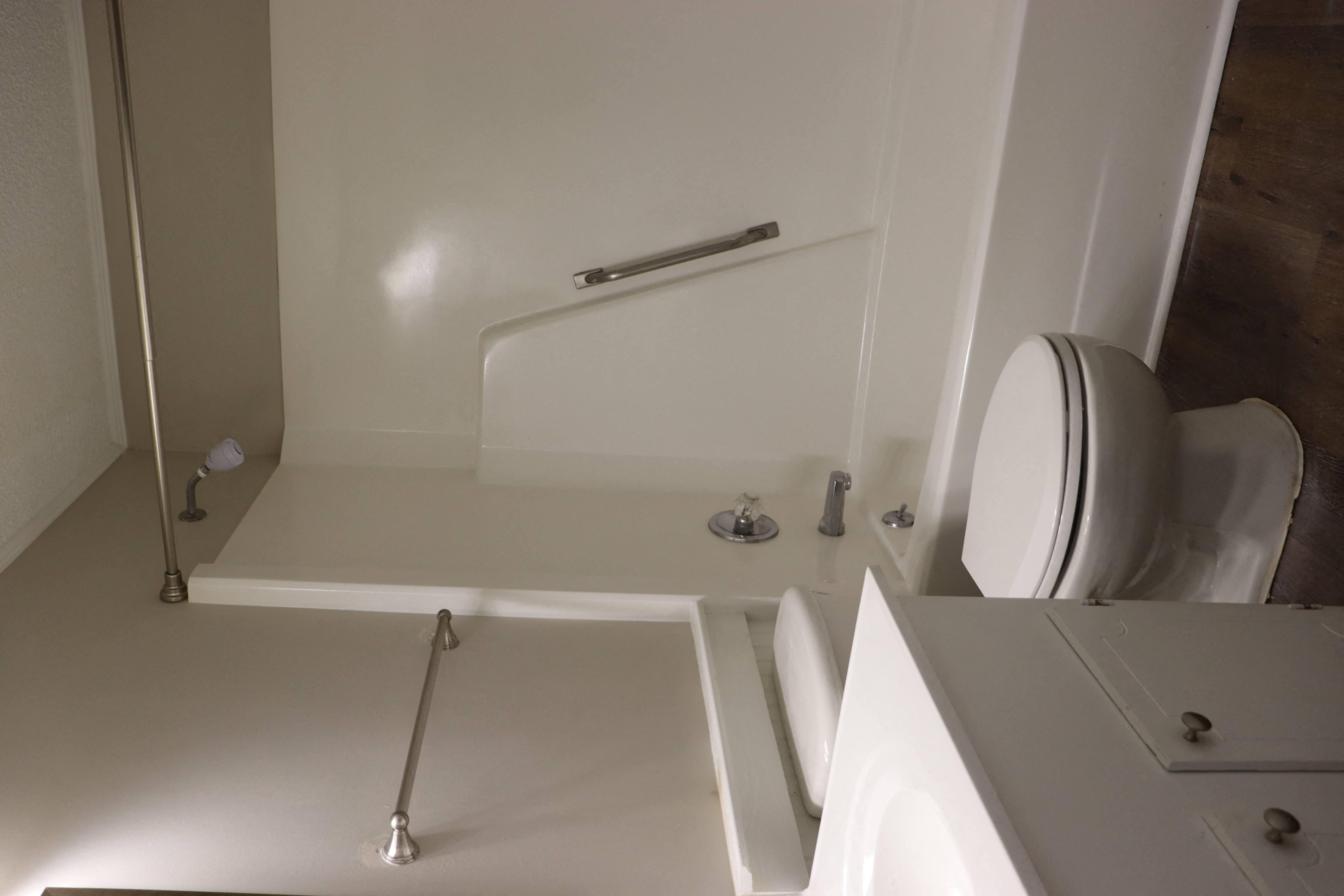 a bathroom with a toilet and a tub and a sink