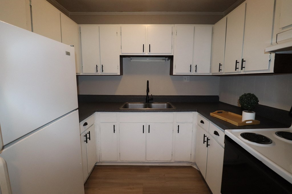 an empty kitchen with white cabinets and a sink
