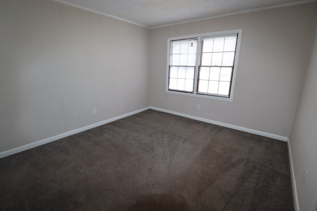 an empty room with carpet and a window