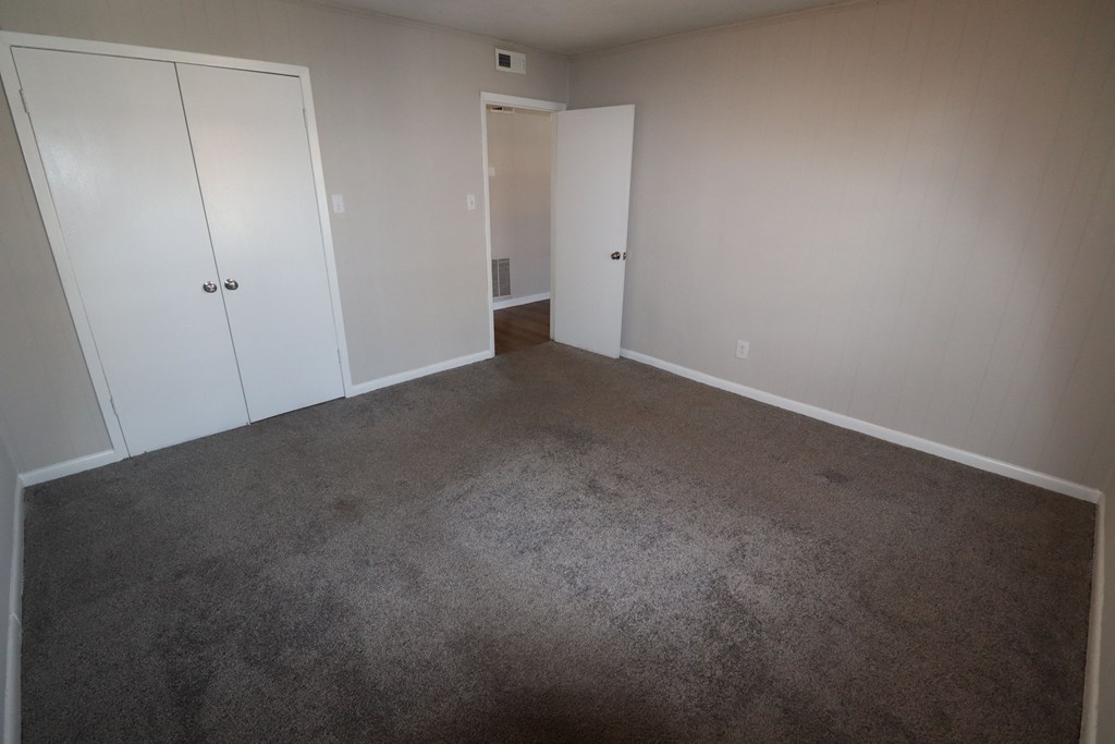 an empty room with carpet and white doors