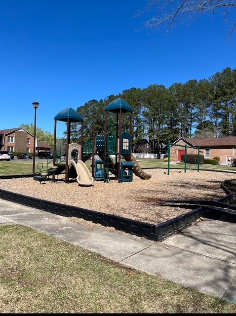 A playground with a slide and a swing set.