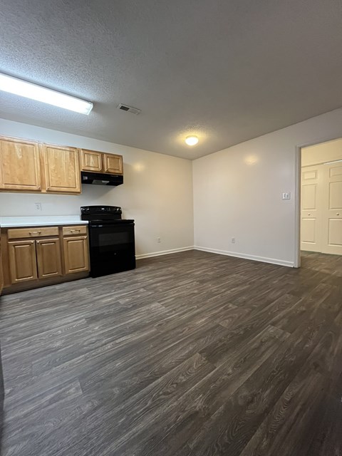 A kitchen with wooden cabinets and a black oven.