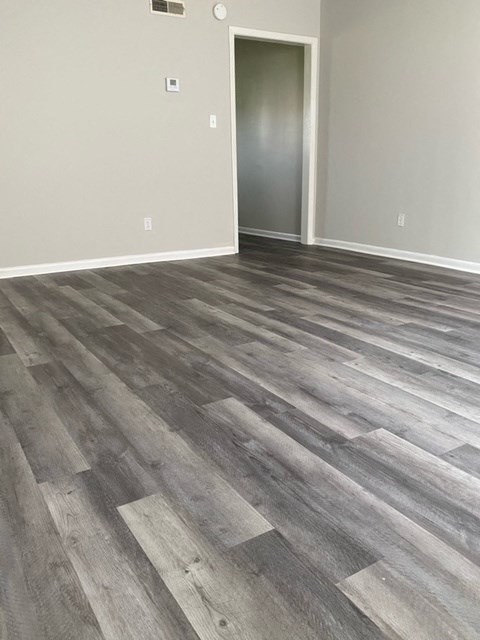a room with a hardwood floor and grey walls