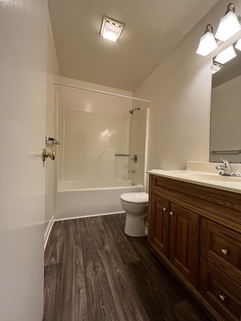 A bathroom with a toilet, sink, and mirror.
