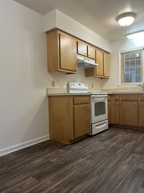 A kitchen with wooden cabinets and a white washing machine.