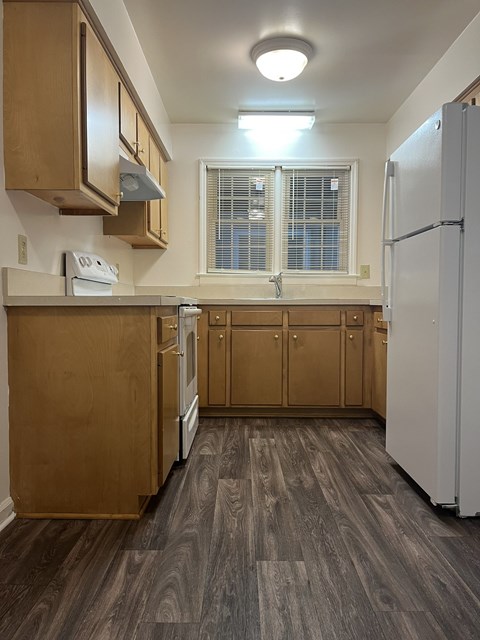 A kitchen with wooden cabinets and a white refrigerator.