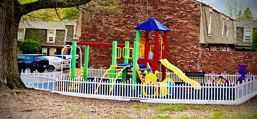 a playground in a yard with a white fence