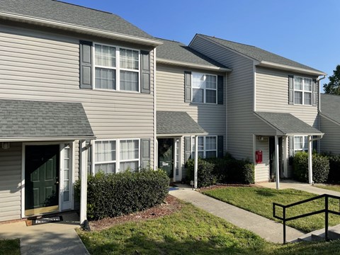 A row of houses with green bushes in front.