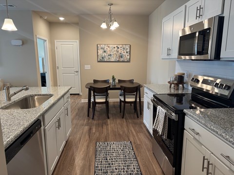 A kitchen with a table and chairs in the middle.