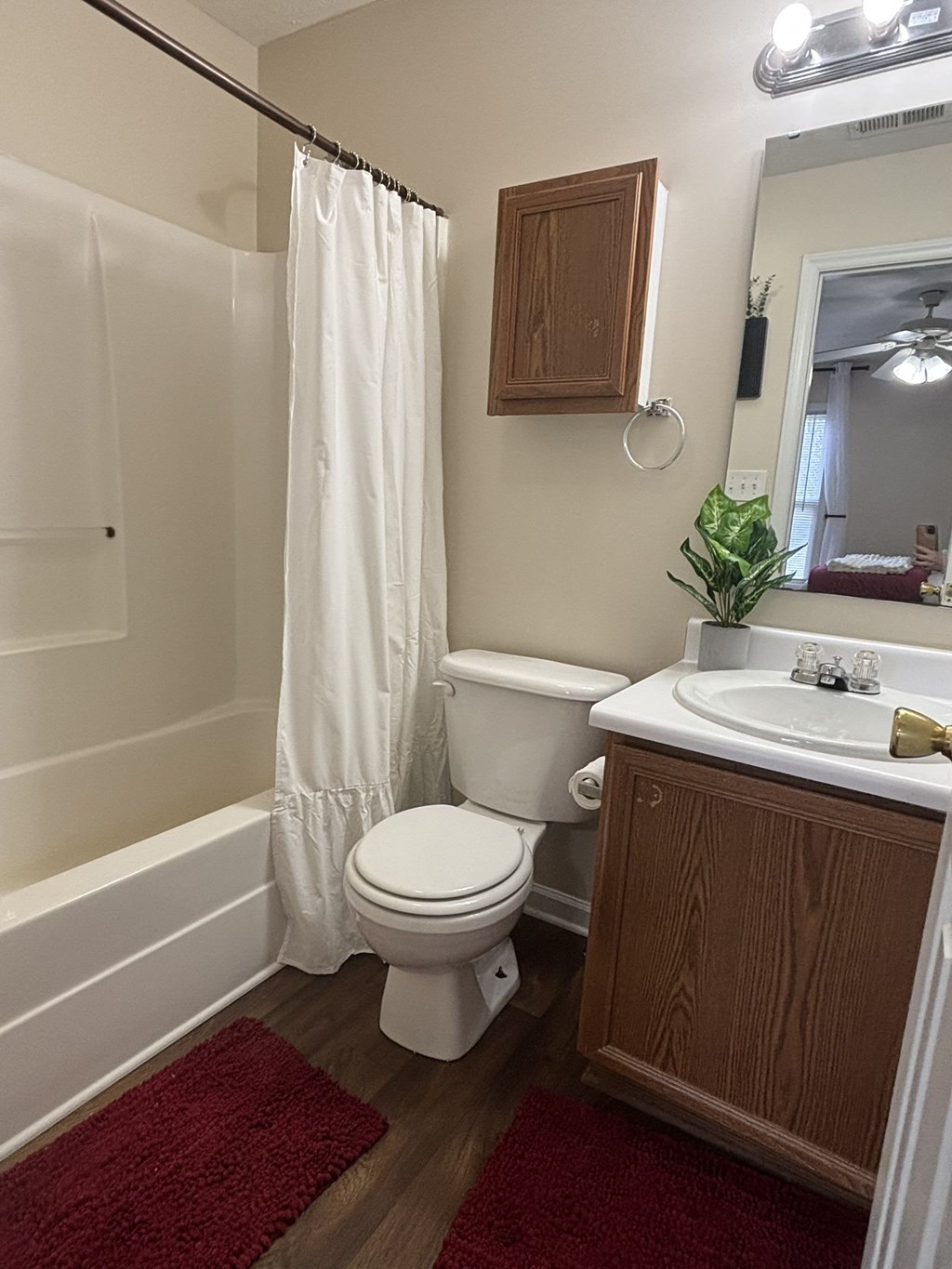 A white toilet with a white shower curtain in a bathroom.