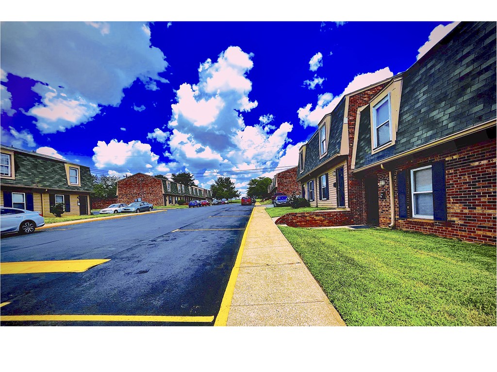 a city street with brick buildings and a blue sky