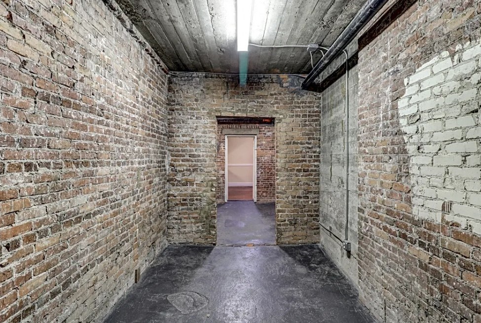 a hallway in a brick building with a door in the end
