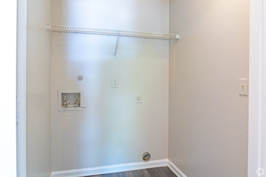 A white wall with a shelf and a switchboard.