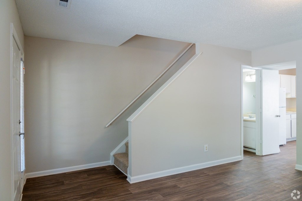 A room with a staircase and wooden flooring.