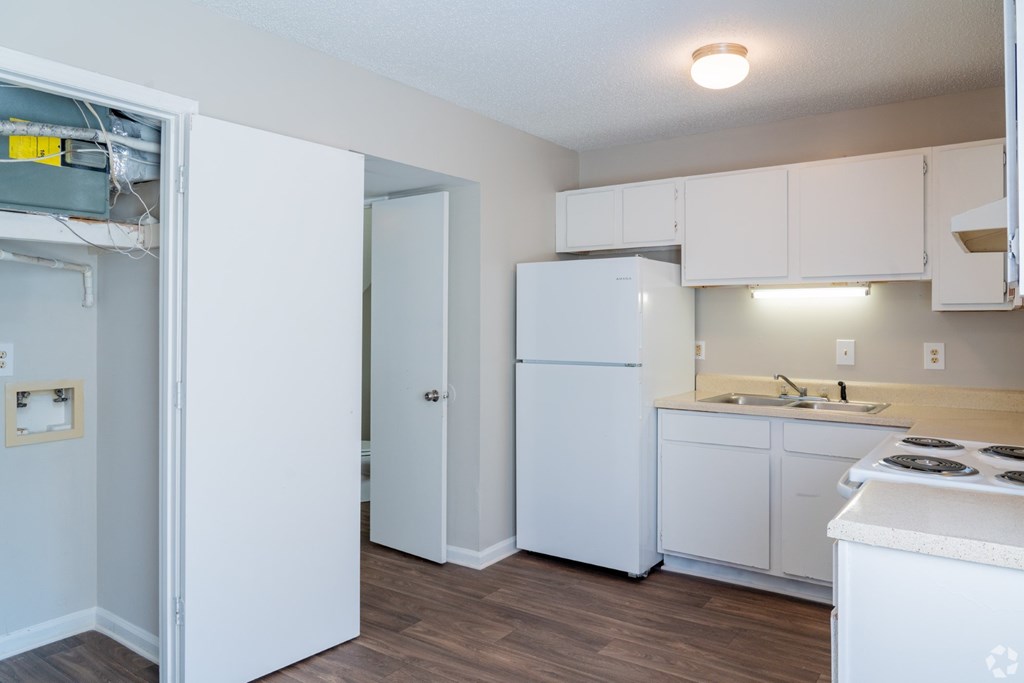 A kitchen with white appliances and cabinets.