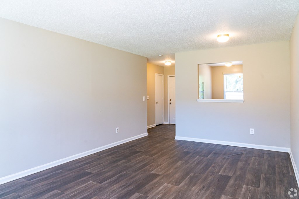 A room with wooden flooring and white walls.