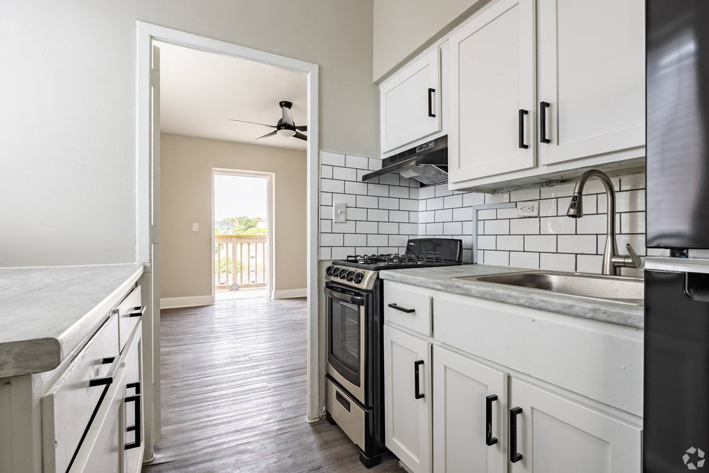 a kitchen with white cabinets and a black stove top oven