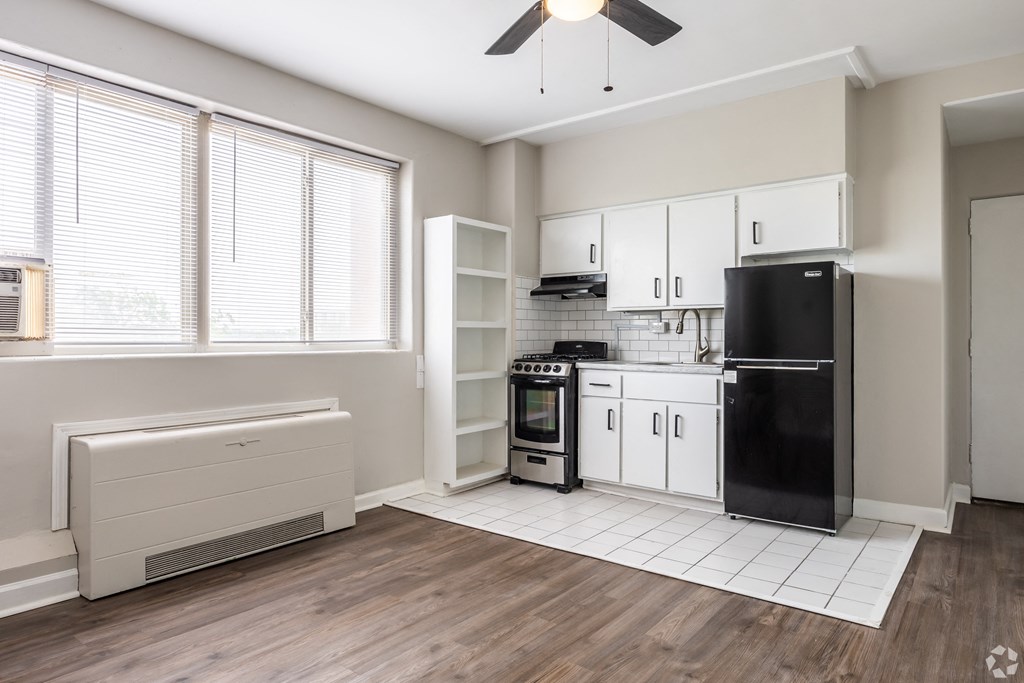 a kitchen with white cabinets and black appliances