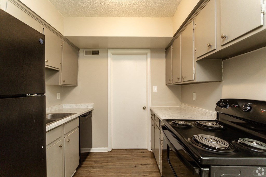 an empty kitchen with a stove and a refrigerator
