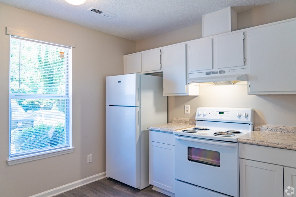 A kitchen with white appliances and cabinets.