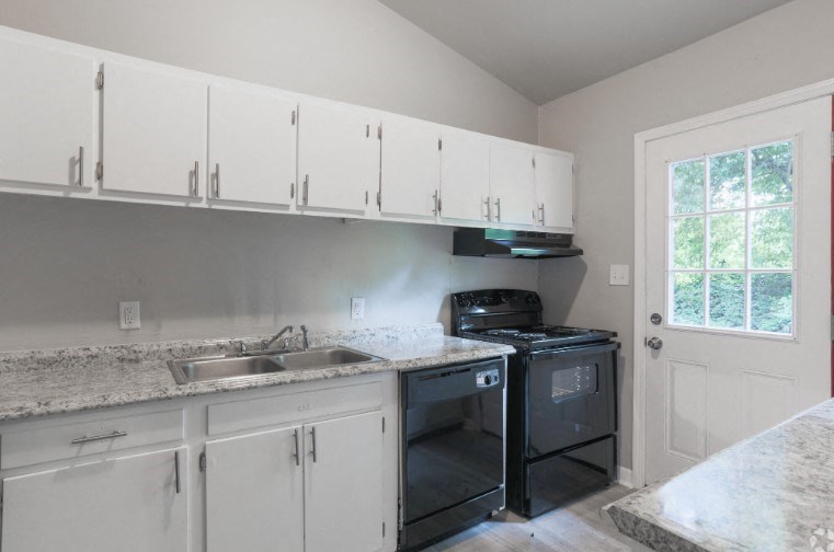 a kitchen with white cabinets and a stove and a sink