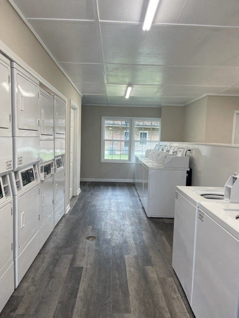 an empty kitchen with white appliances and a wood floor