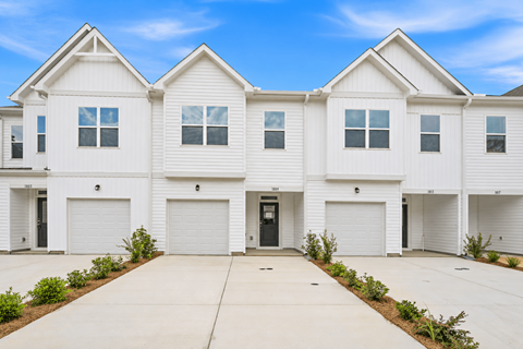 A row of white houses with black doors and windows.