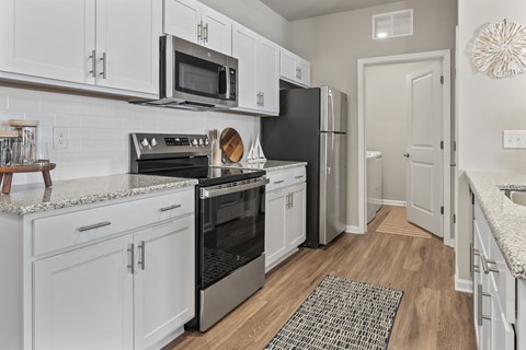 A kitchen with white cabinets and black appliances.