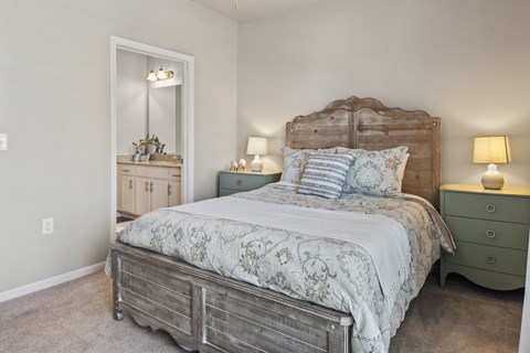 A bedroom with a large bed and a dresser with a mirror.