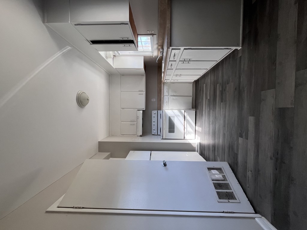 A white refrigerator in a room with grey walls.