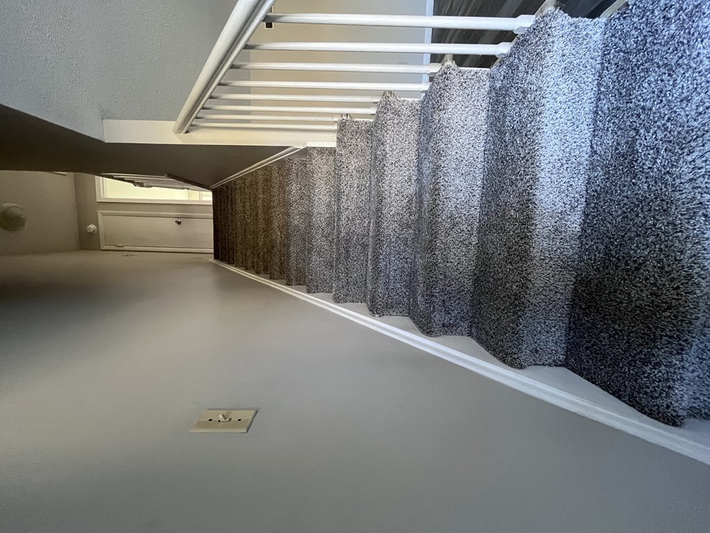 A long hallway with a row of curtains on the wall.