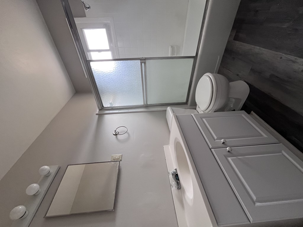 A modern bathroom with a toilet, sink, and mirror.
