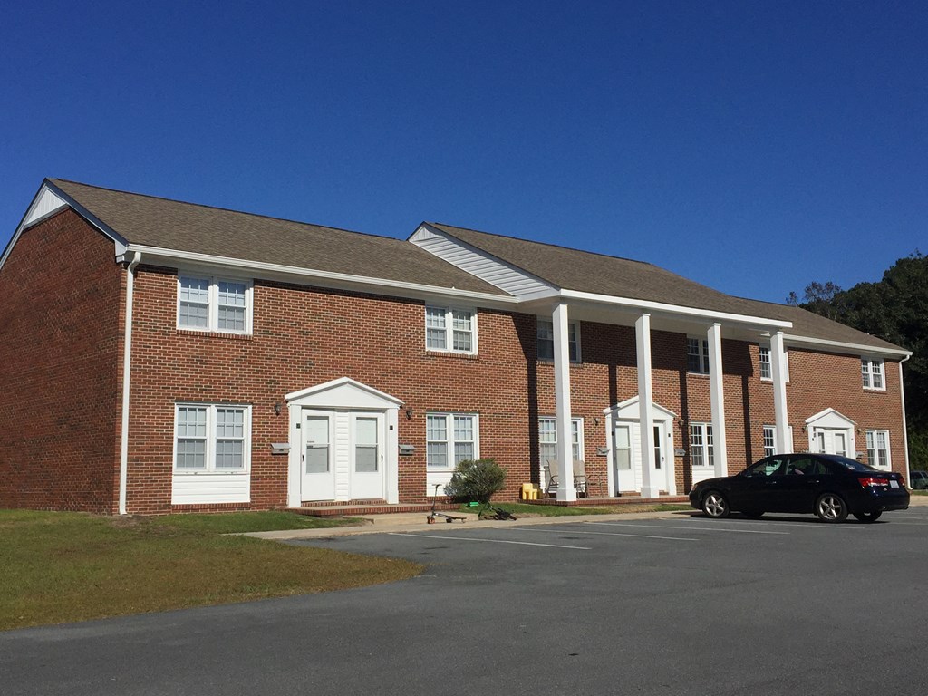 a large brick building with a car parked in front of it