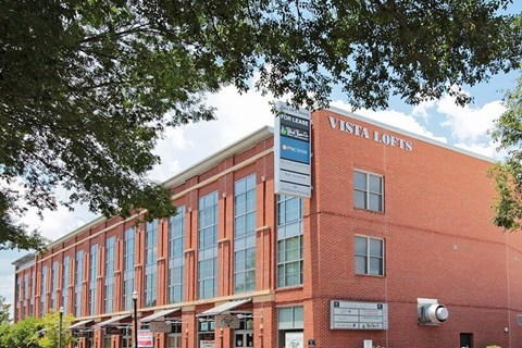 A red brick building with a sign that says Vista Lofts.